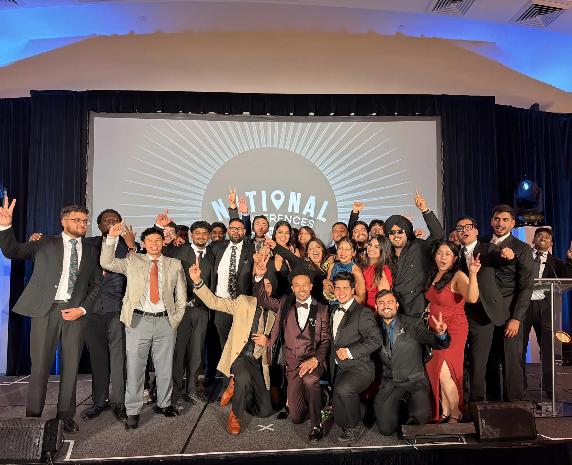 The DucMeta team celebrating together on stage at a national sales conference